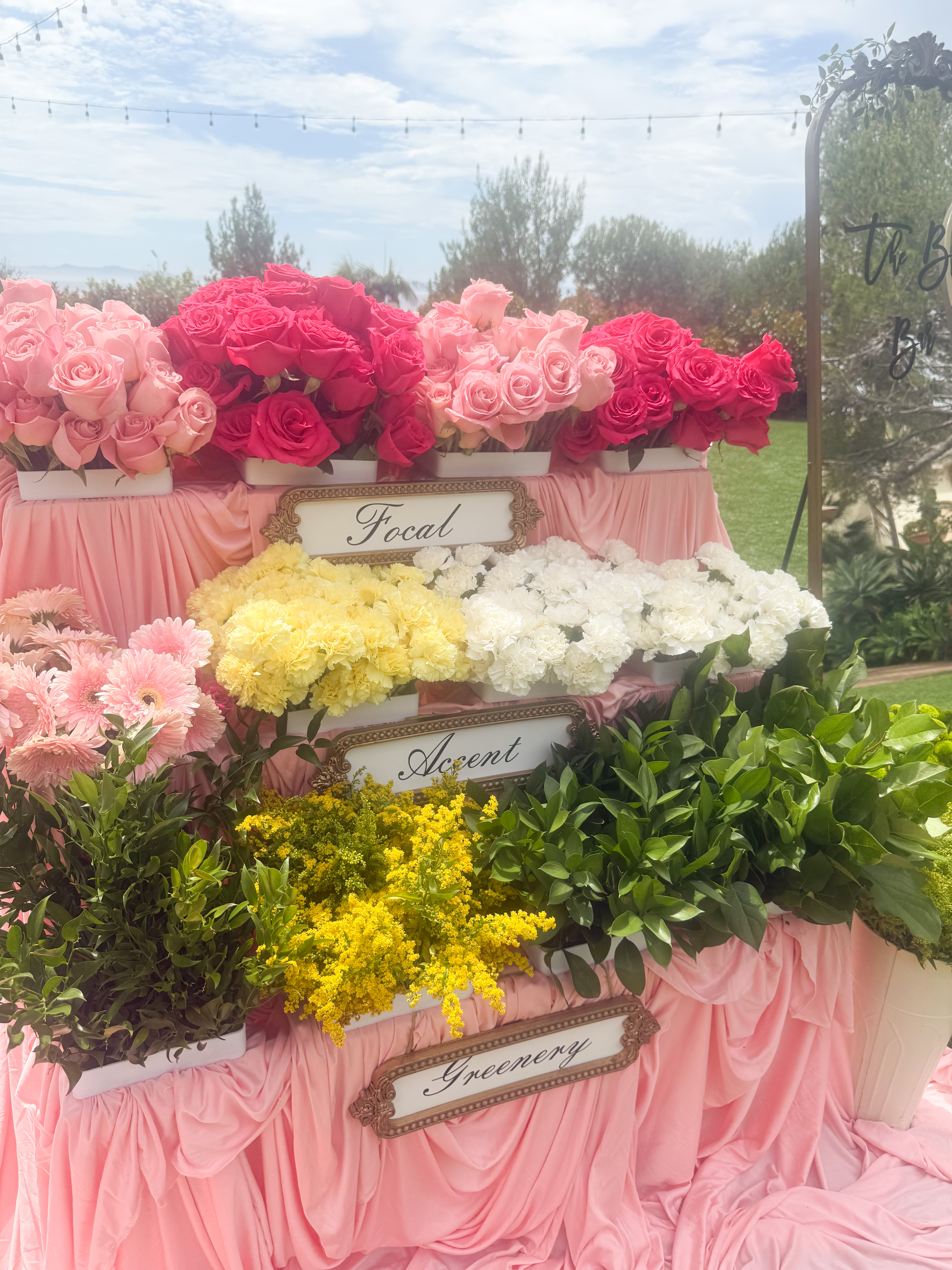 Three-tiered flower bar station with focal blooms, accent flowers, and greenery