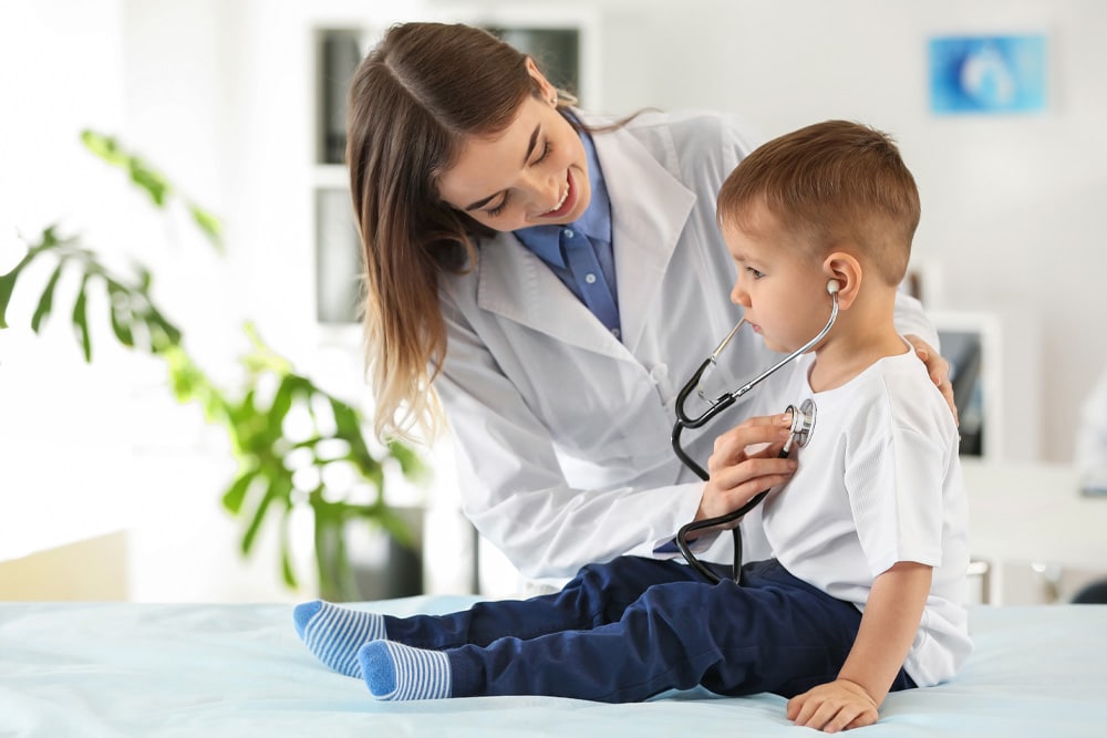Doctora atendiendo a niño con póliza de salud
