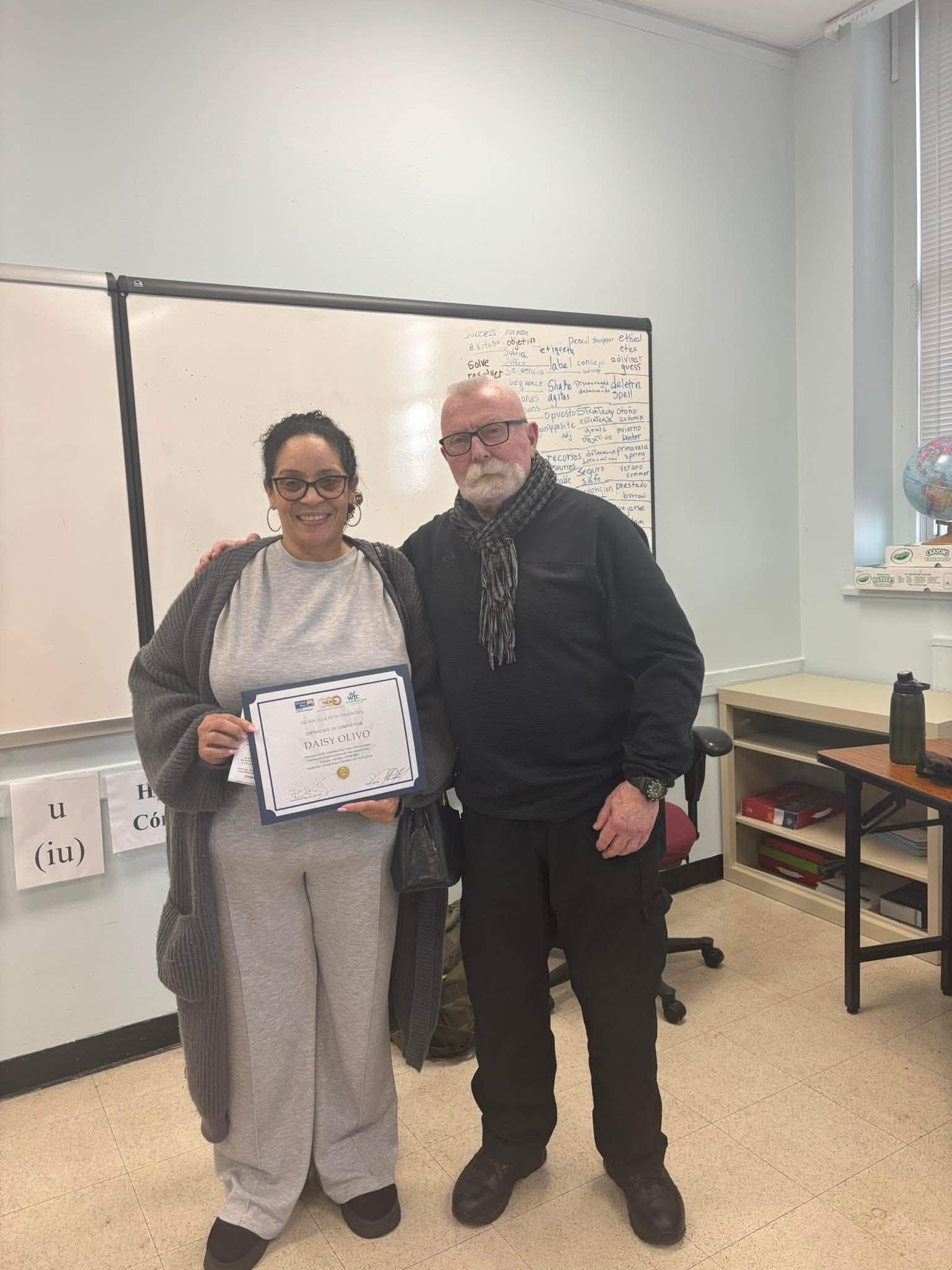 Daisy Olivo receiving her De-Escalation Training Certificate of Completion with instructor