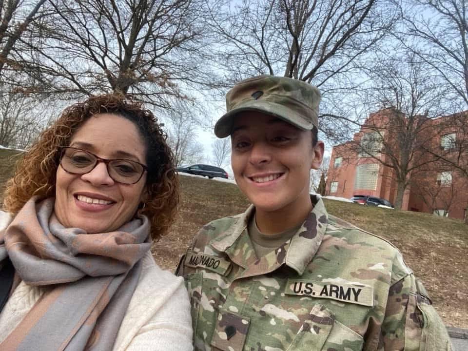 Daisy Olivo smiling proudly alongside a U.S. Army soldier family member