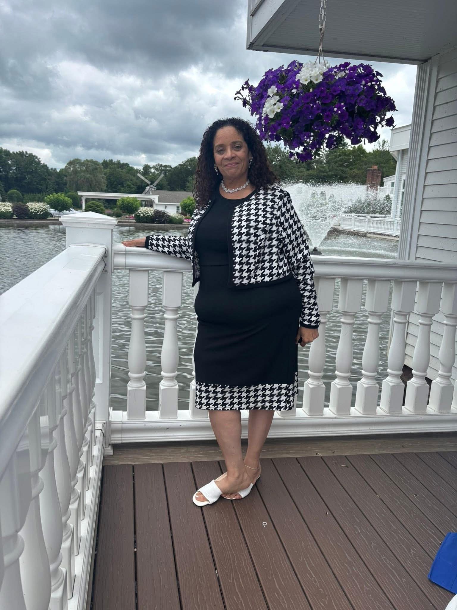 Daisy Olivo posing gracefully at a lakeside event venue during a community leadership gathering