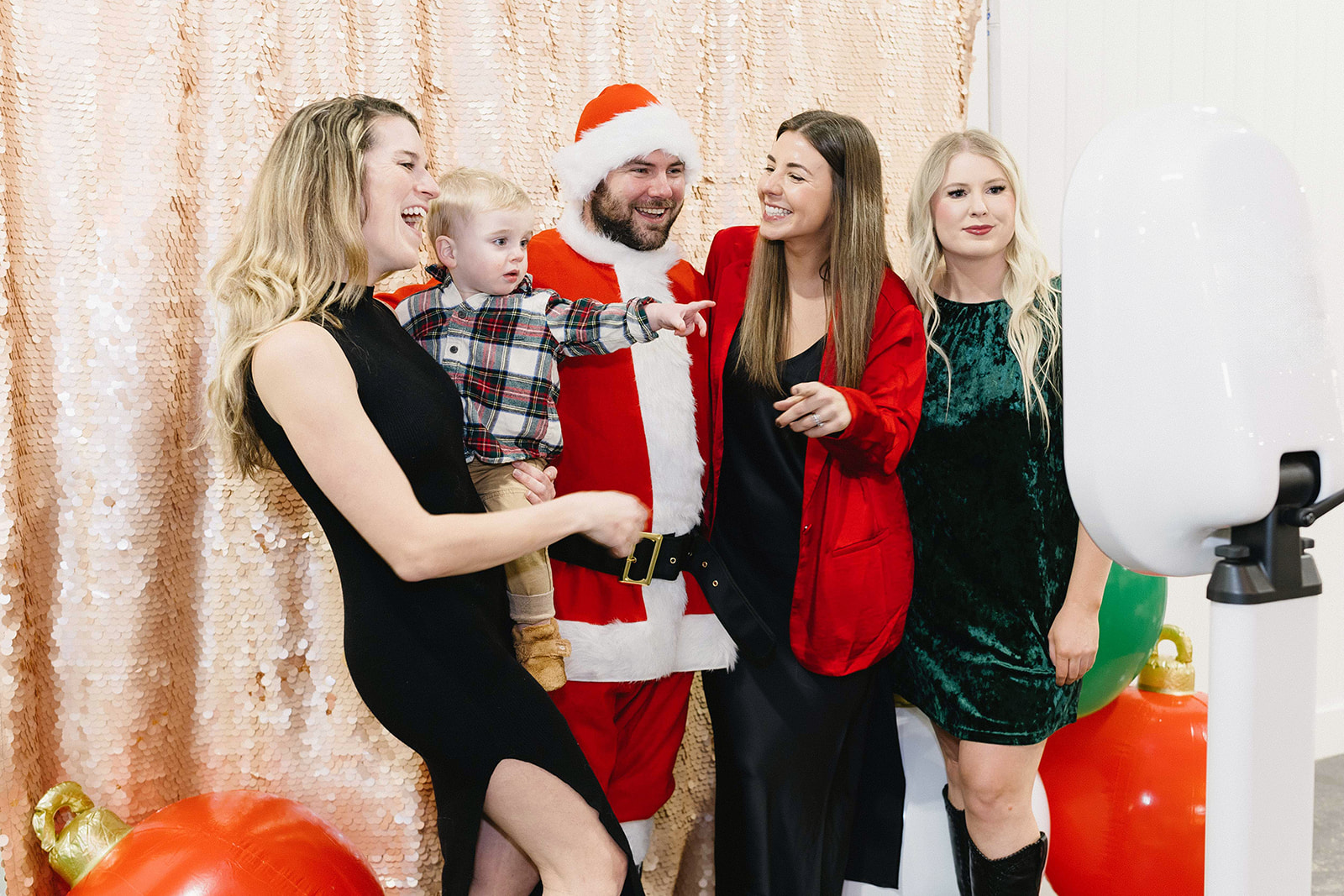 Guests celebrating with Santa at Photo Love station with giant holiday ornaments