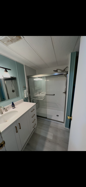 Southern Shower Pros completed bathroom project - blue vanity and modern shower