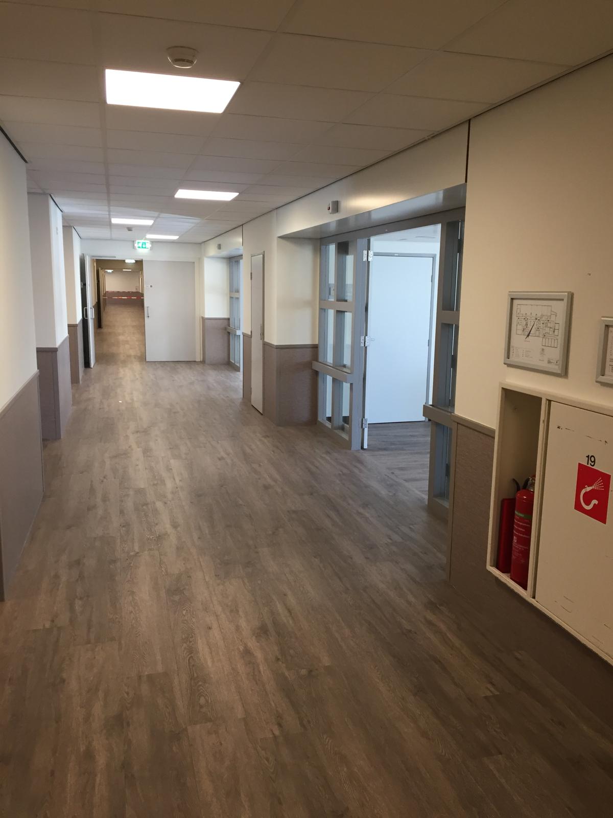 Gemeenschappelijke ruimte - ruime gang met houten vloer en lichte afwerking