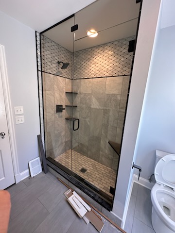 Custom frameless glass shower door and panel