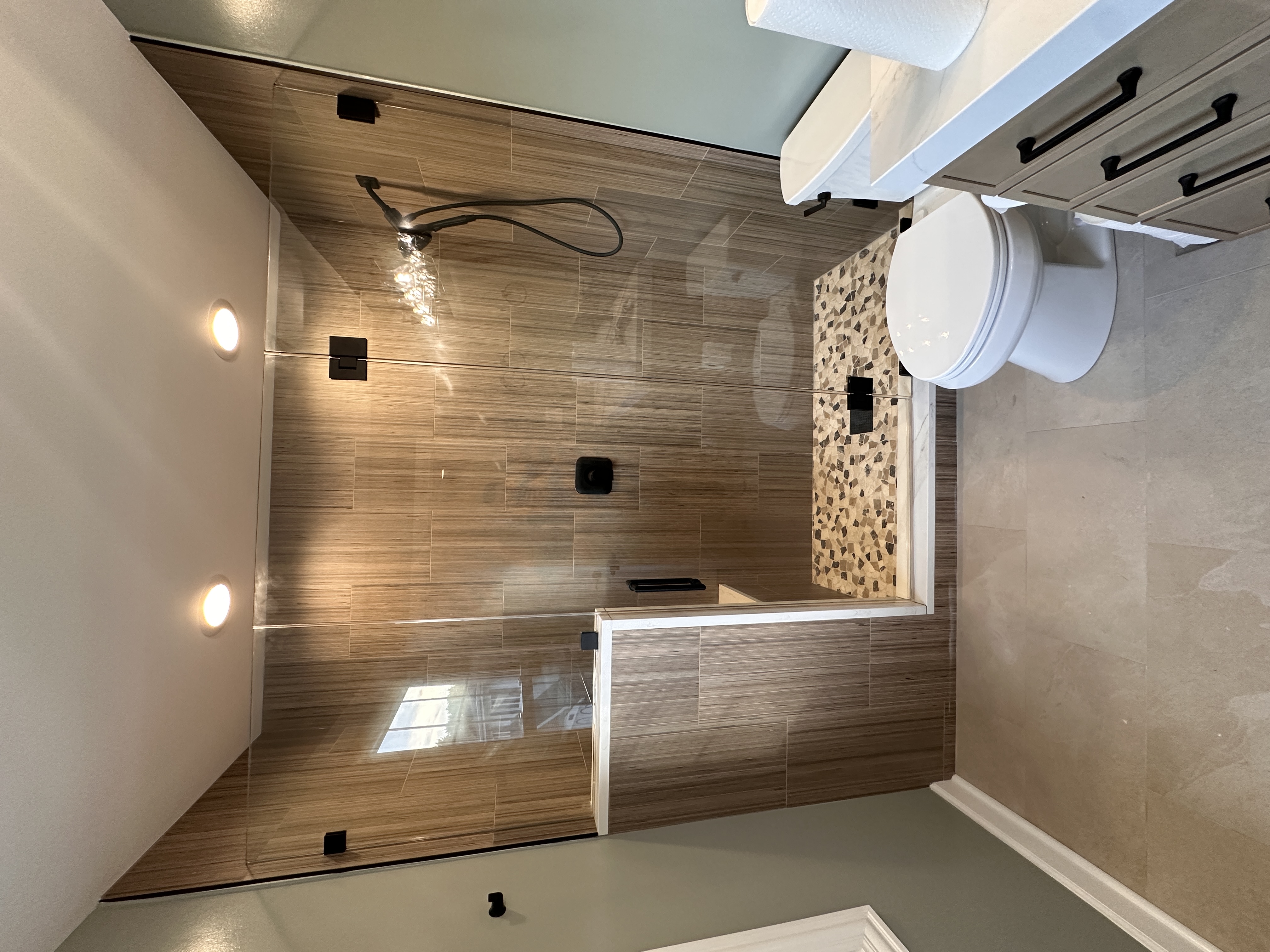 Walk-in shower with custom frameless glass panel