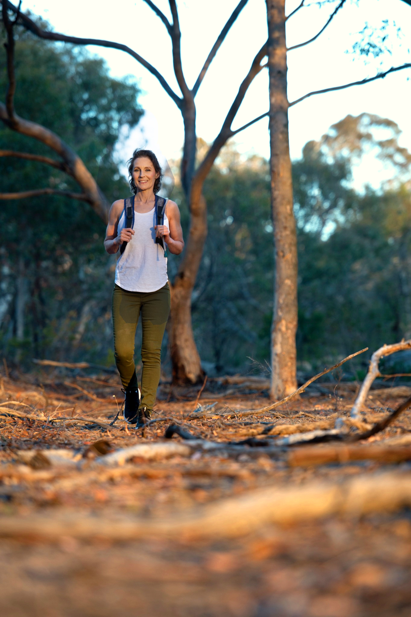 Katie Larking walking in the bush with backpack
