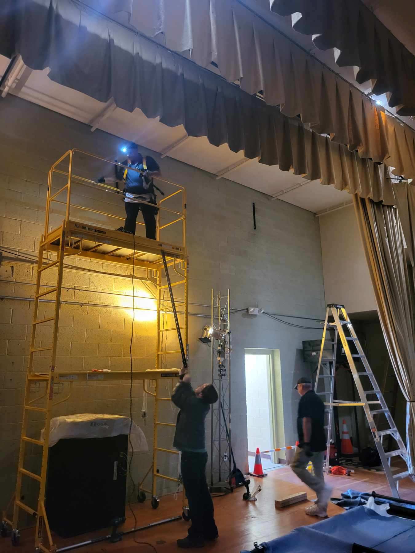 Action Technology Services technicians installing audio visual equipment from elevated scaffolding