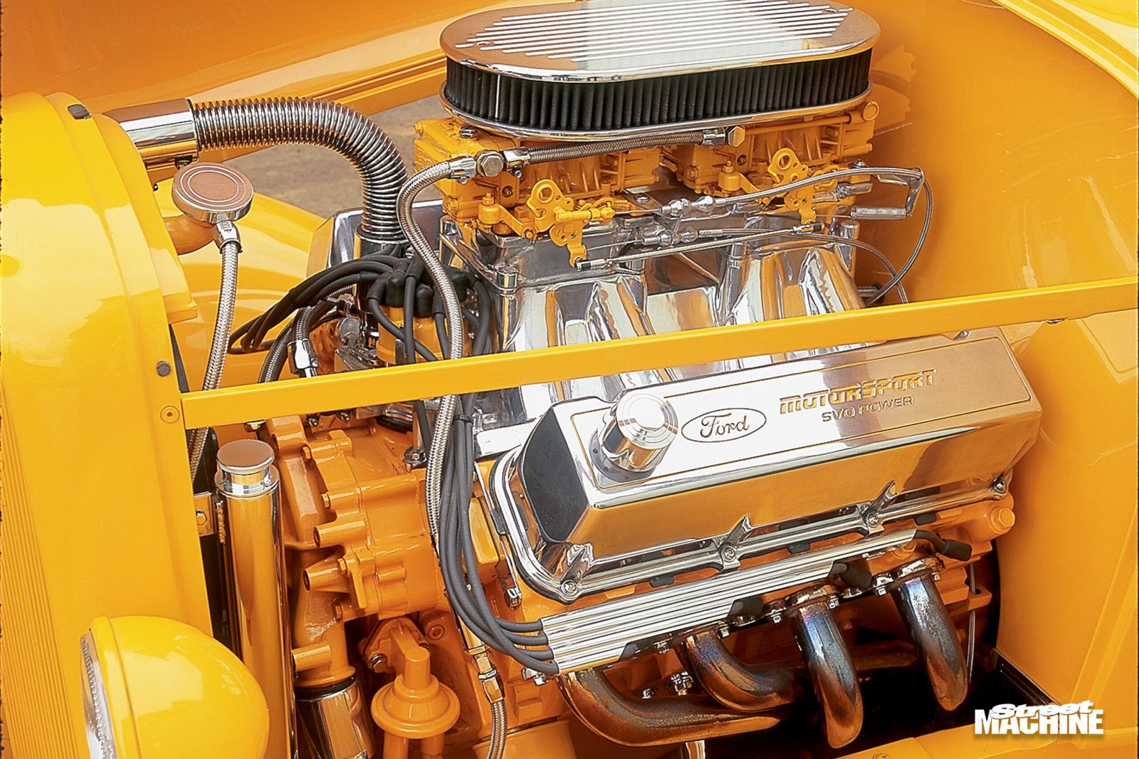 Close up of a polished Ford Motorsport SVO power engine in a yellow hot rod