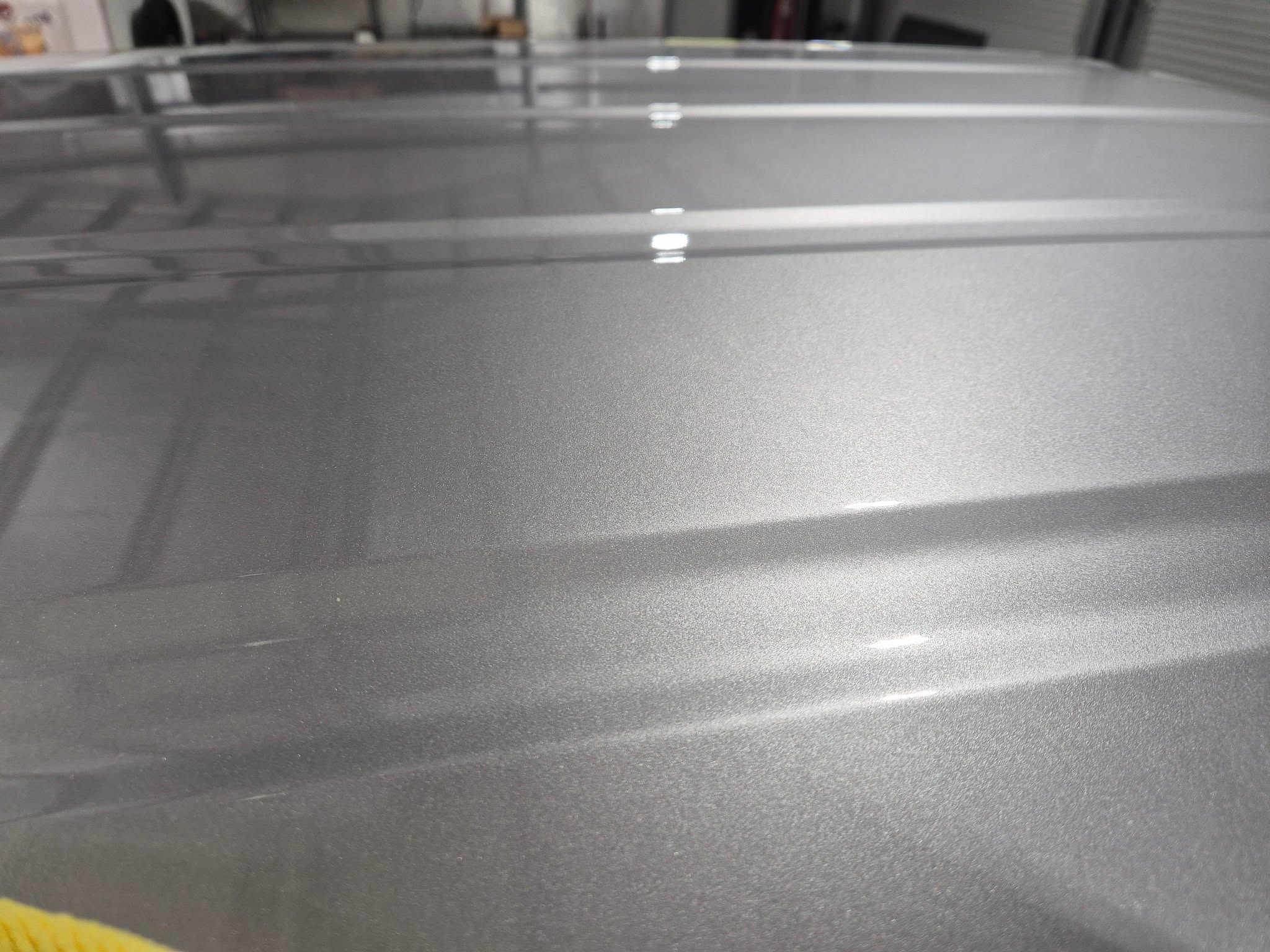 Close up of a silver car roof showing flawless glossy paint reflection after ceramic coating