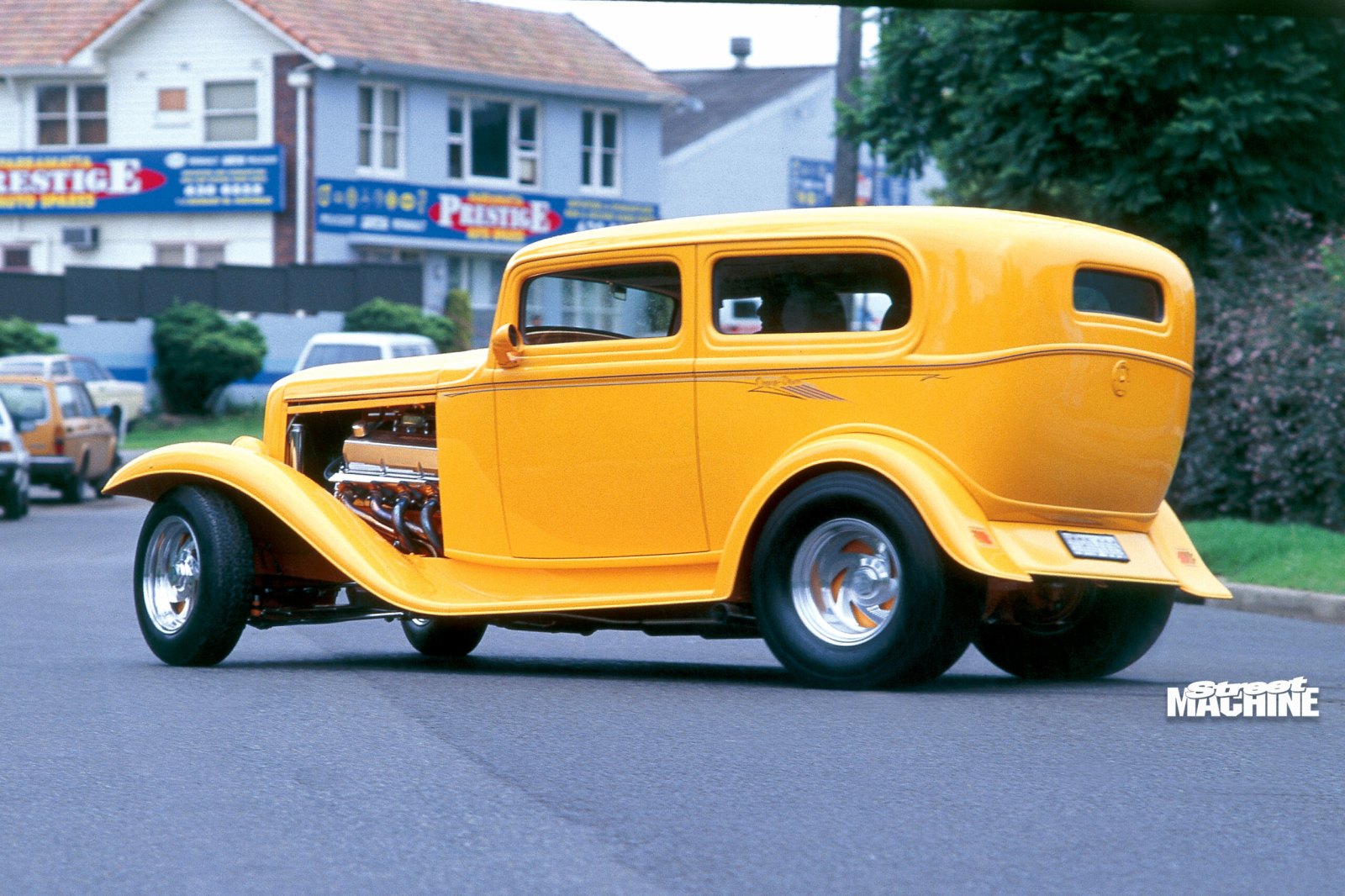Rear view of yellow 1932 Ford hot rod on the street
