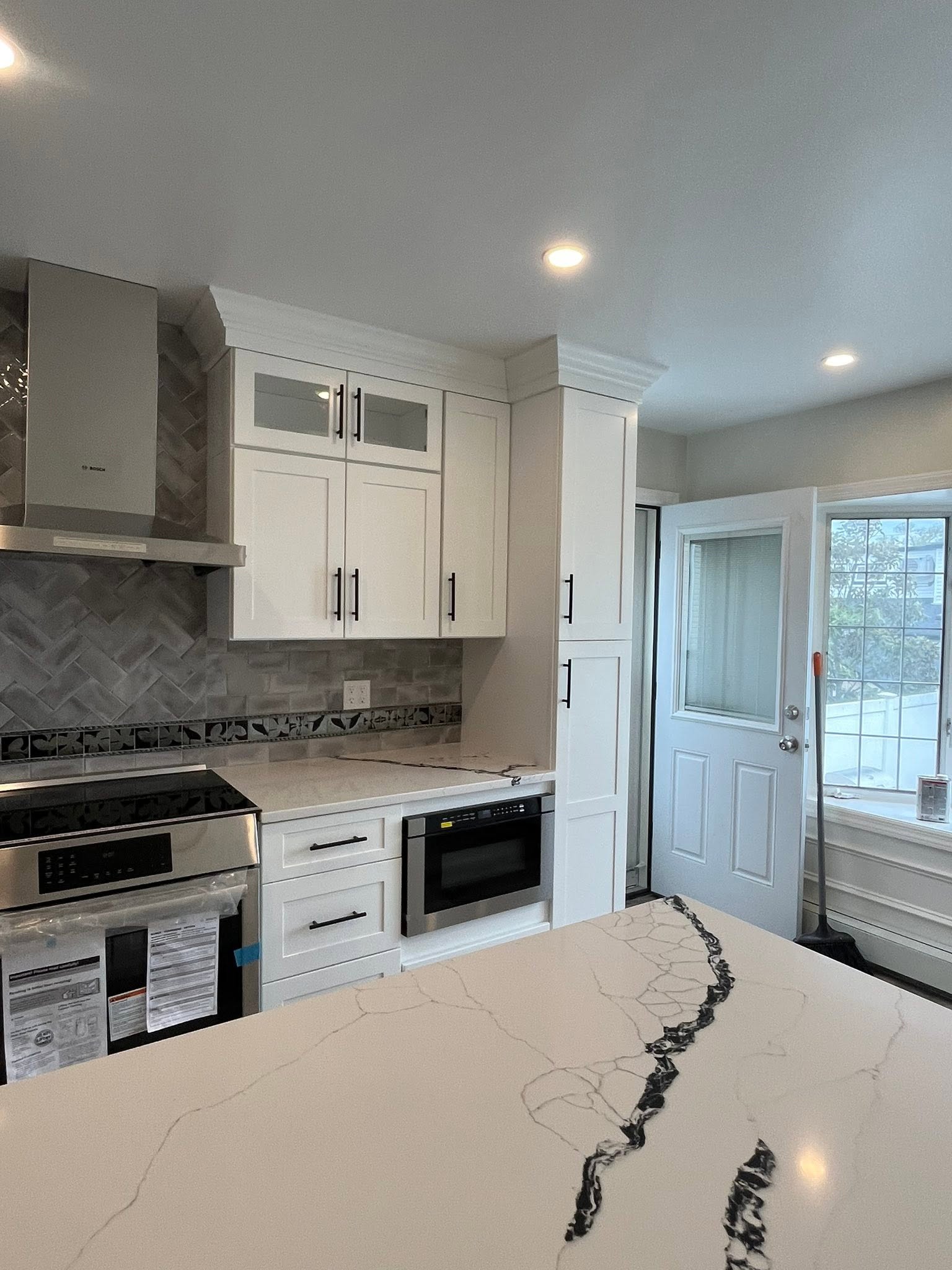 Kitchen remodel with built-in microwave and white cabinets