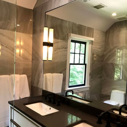 Modern bathroom vanity with large mirror and wall sconce