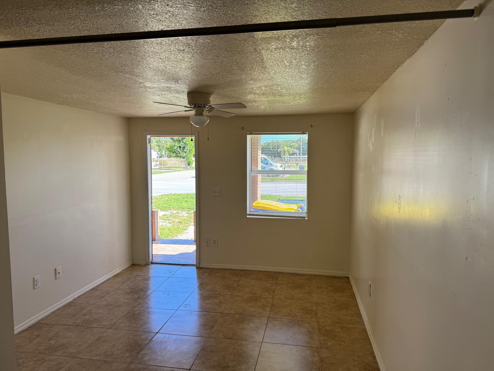 Turnkey duplex interior with tile flooring and open doorway to exterior, Fort Pierce investment property.