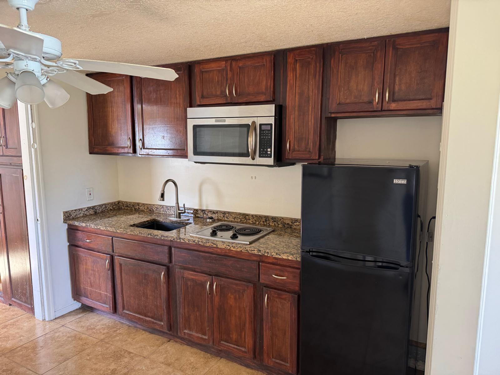 Turnkey duplex kitchen with granite countertops, tile flooring, and stainless steel appliances in Fort Pierce,