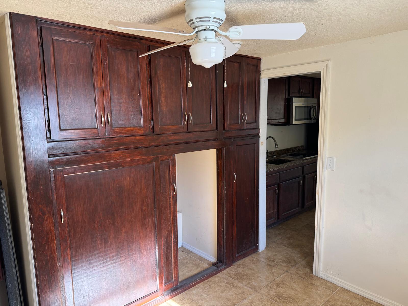 Turnkey duplex kitchen with dark wood cabinetry, granite countertops, and tile flooring in Fort Pierce,
