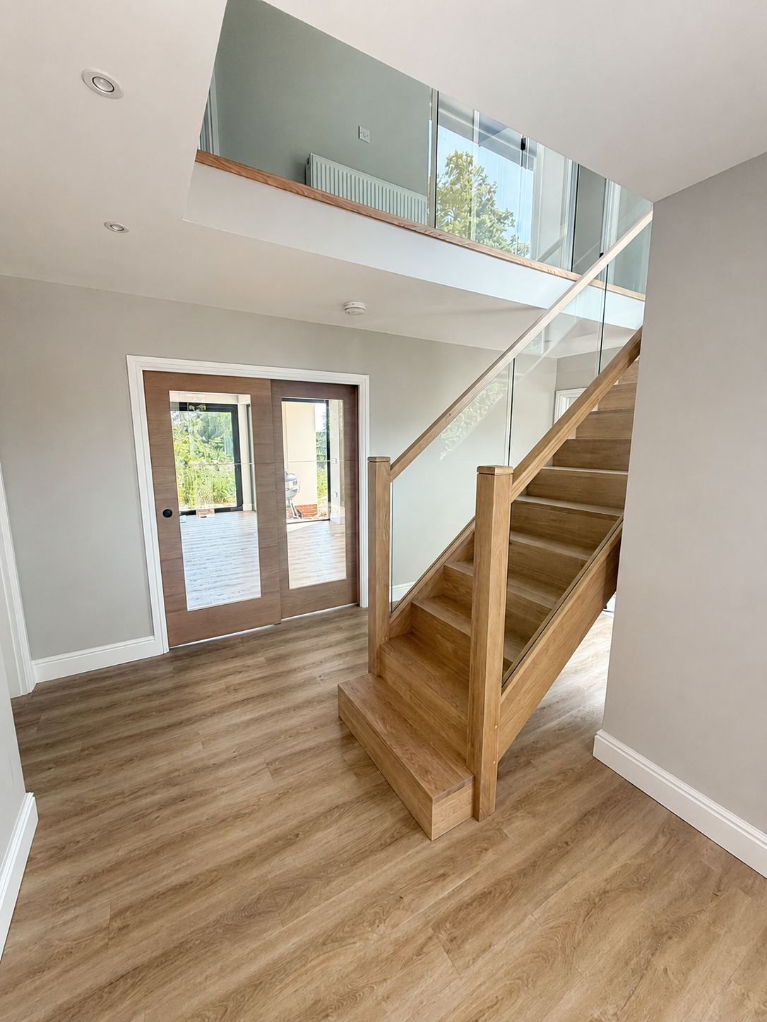 Bespoke staircase refurbishment completed by Milano Home Improvement in Halesowen, featuring oak handrails, glass balustrades and precision joinery.