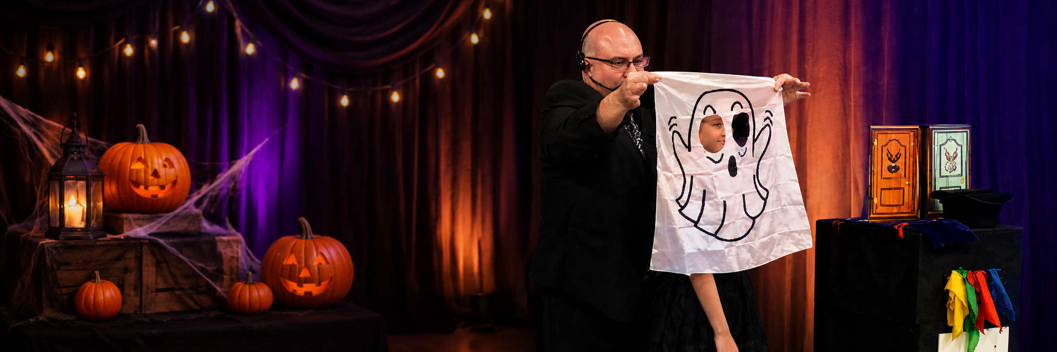 Mike Raymer performing Halloween ghost magic trick with a young volunteer