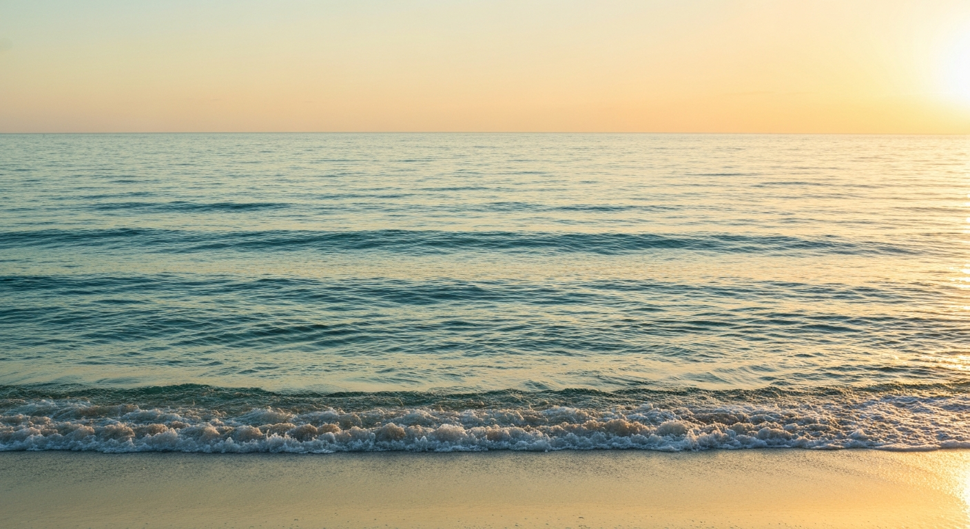 Quiet ocean horizon where the sea meets a warm gold morning sky
