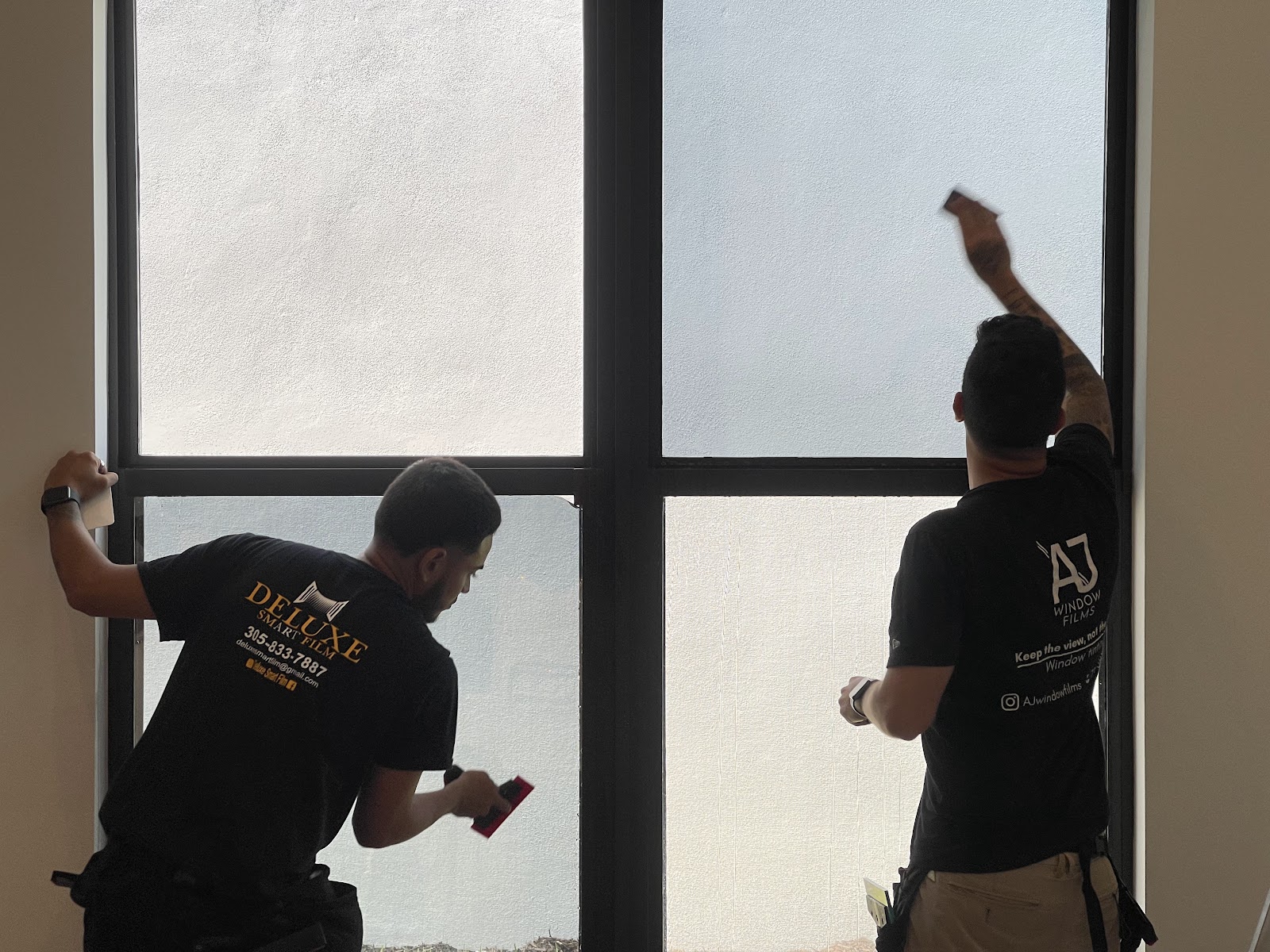 Deluxe Smart Film technicians applying switchable smart film to window panes in Boca Raton