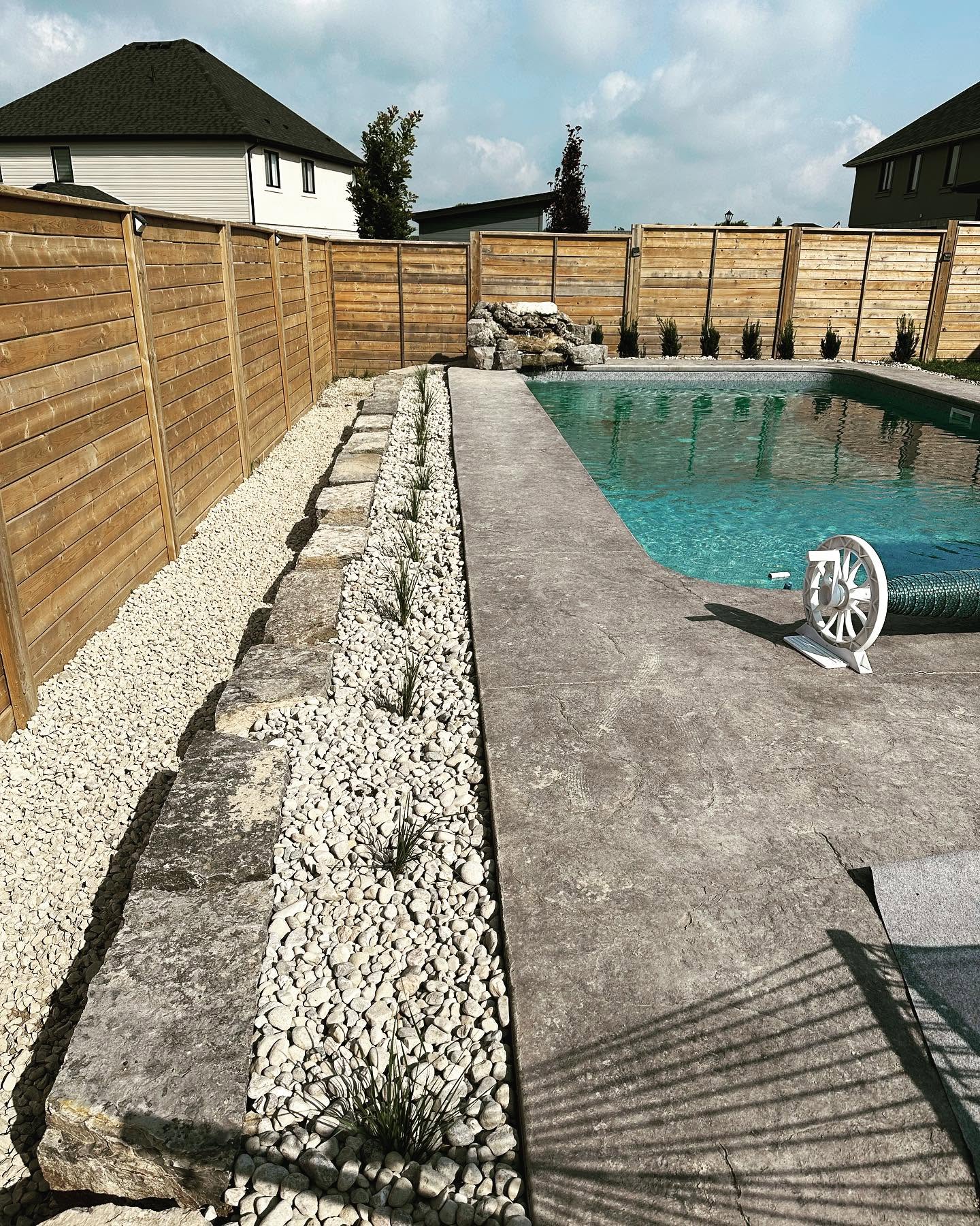 Poolside landscaping with decorative stones - London Landscape Design
