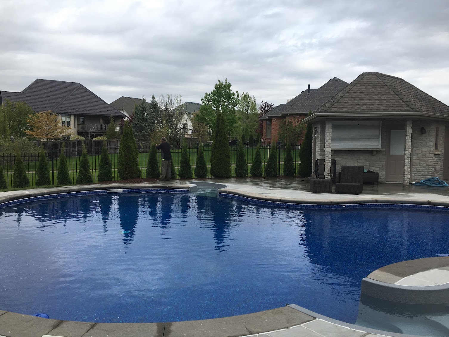 Inground swimming pool with natural stone patio surround and cabana in London, Ontario