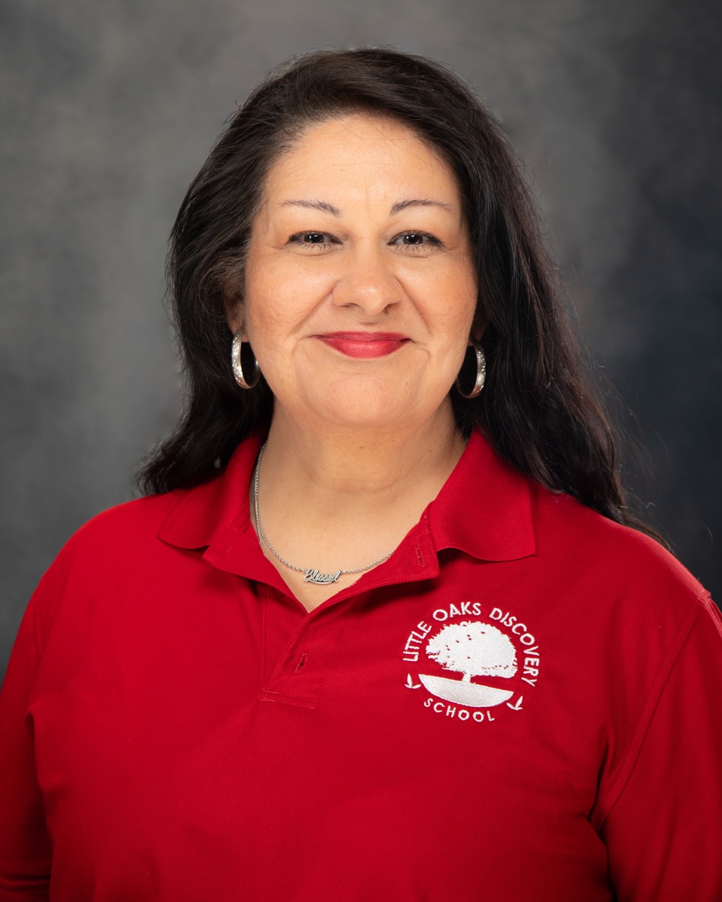 Professional studio headshot — female professional in red polo