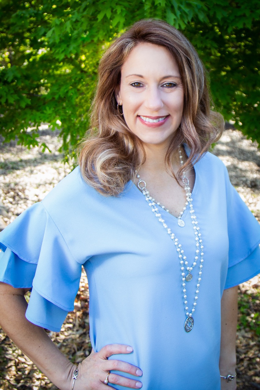 On-location professional headshot — woman in light blue dress outdoors