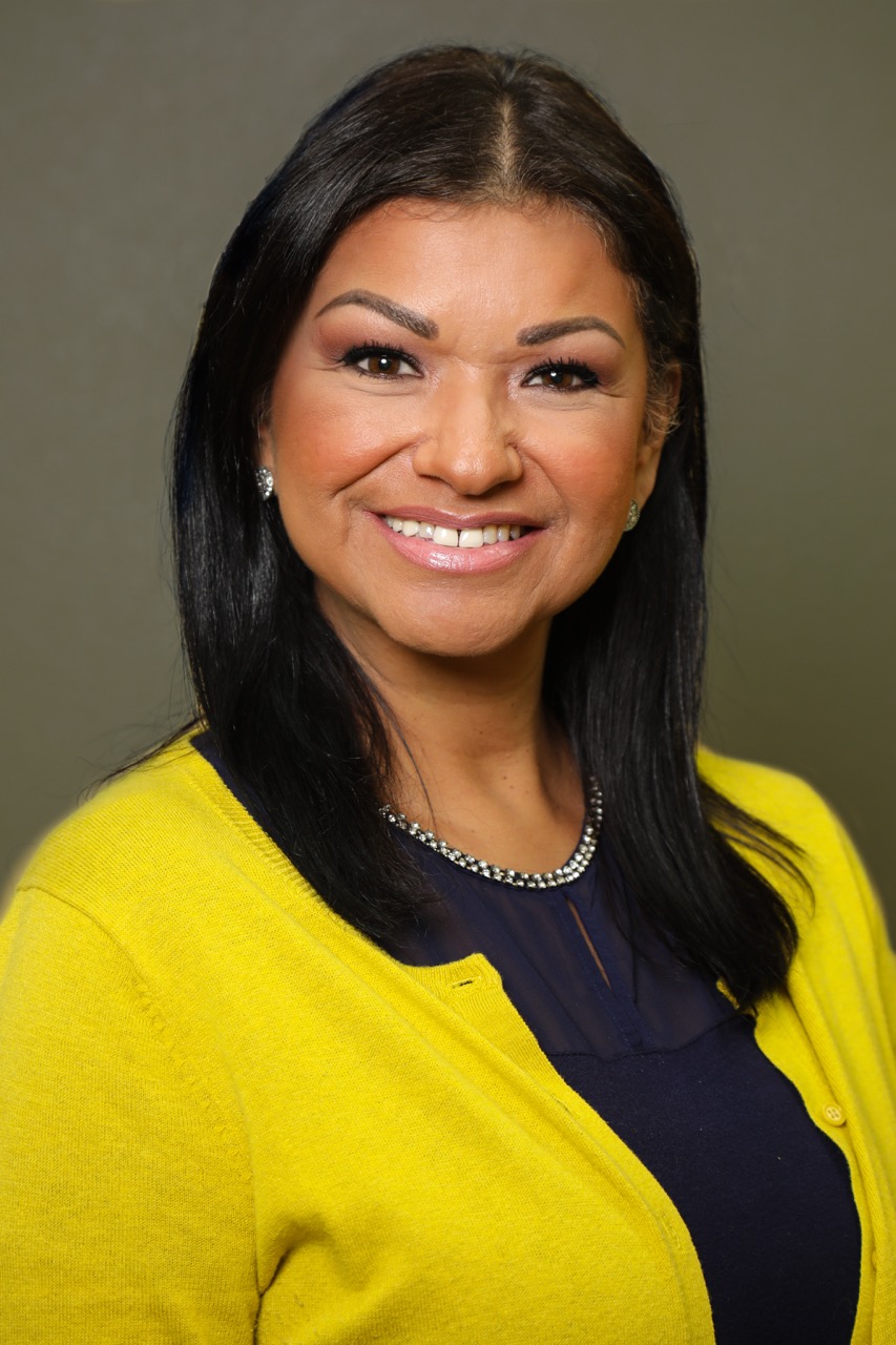 Professional studio headshot — female professional in yellow cardigan