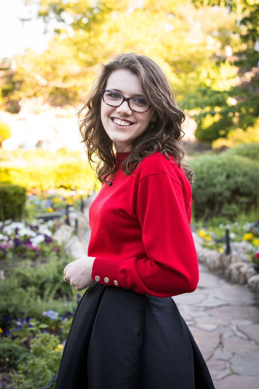 On-location professional headshot — woman in red sweater in garden