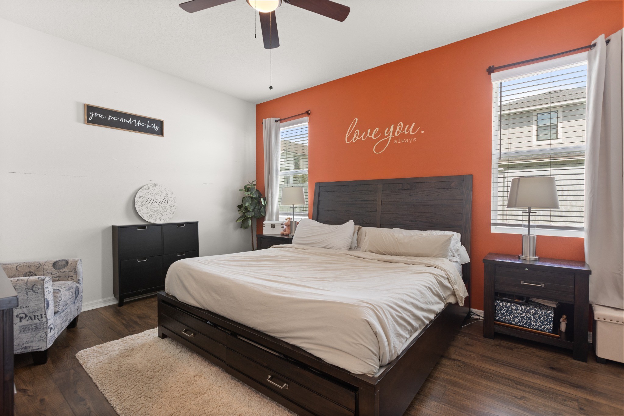 2401 Avian Loop Kissimmee FL - Spacious main-floor primary bedroom with rich wood-look flooring, ceiling fan, dual windows, and ample space for king furnishings
