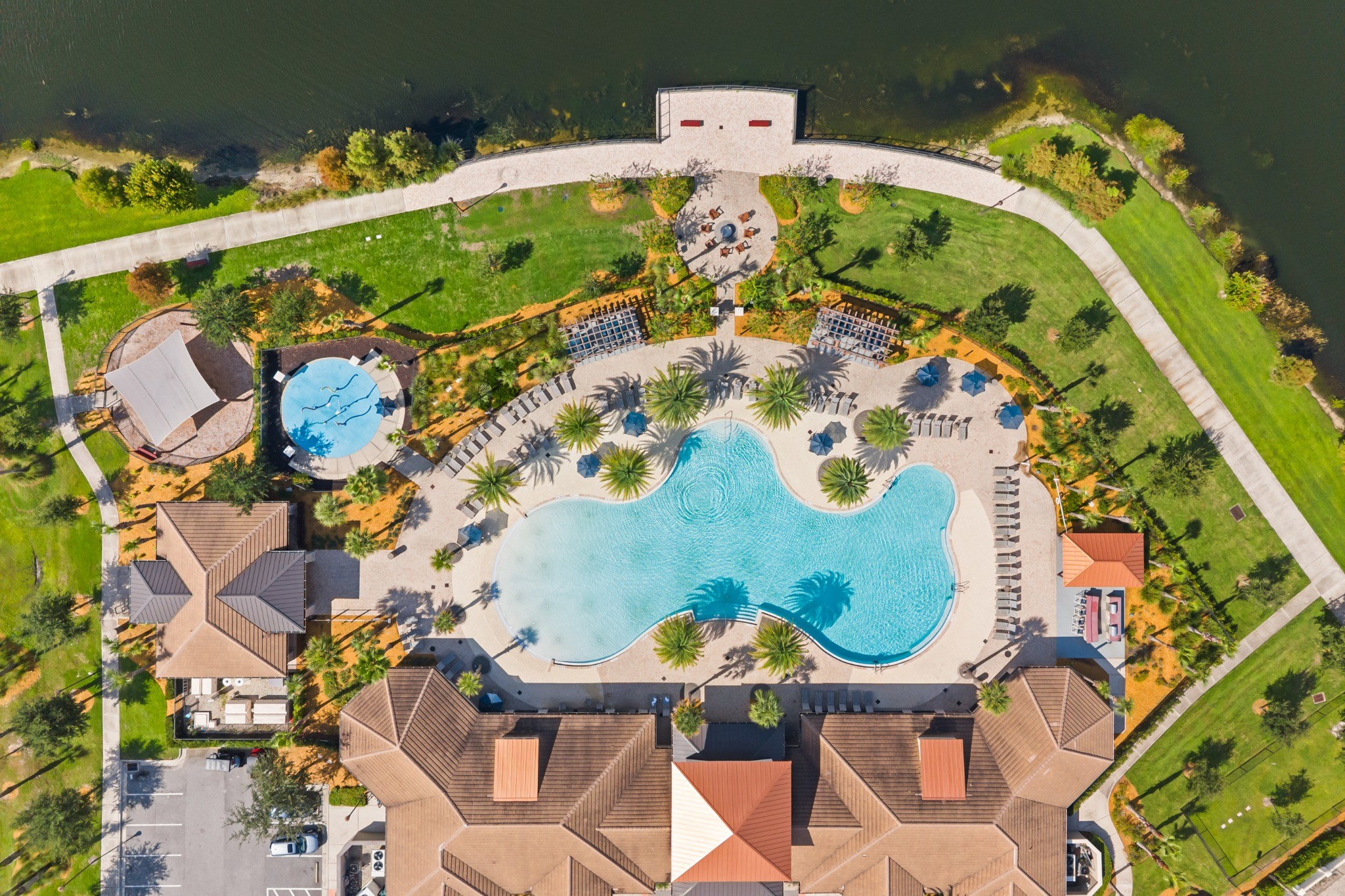 Aerial overview of Tapestry community amenity complex showing resort-style community pool, clubhouse, splash pad, and recreation grounds in Kissimmee