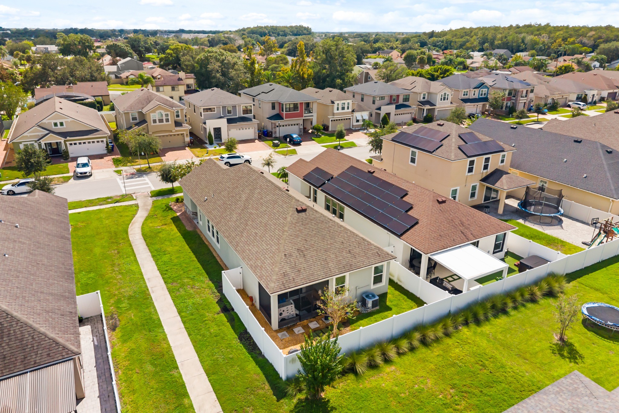 2401 Avian Loop Kissimmee FL - Aerial view showing the single-story residence from the rear, screened lanai, fenced backyard, and surrounding residential setting in Tapestry