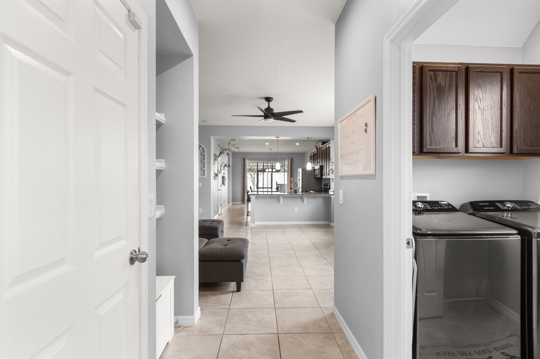 2401 Avian Loop Kissimmee FL - Interior hallway circulation showing dedicated laundry room with upper cabinetry and open view toward living spaces