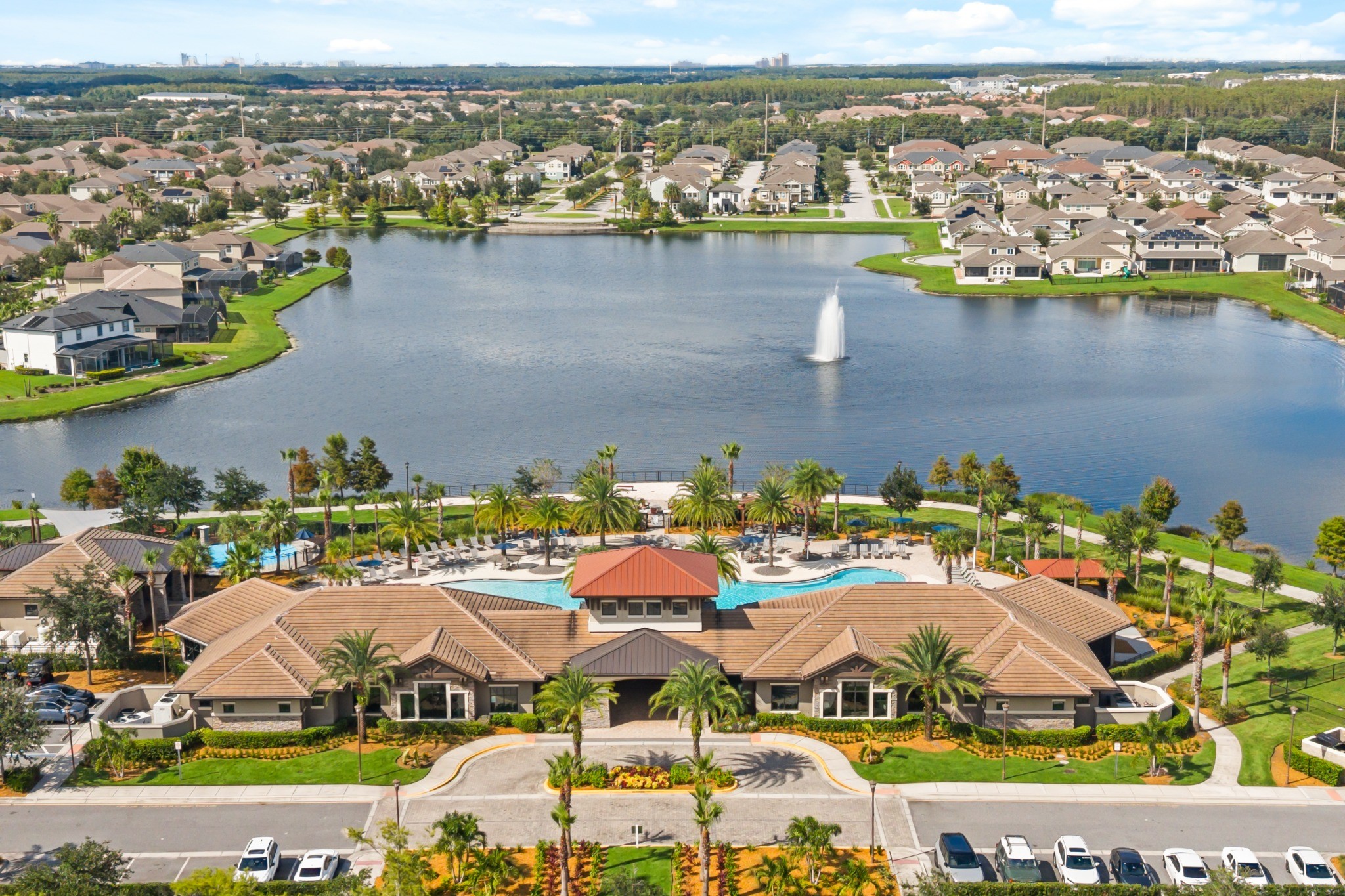 Aerial view of Tapestry community clubhouse, resort-style community pool, fountain lake, and neighborhood grounds in Kissimmee