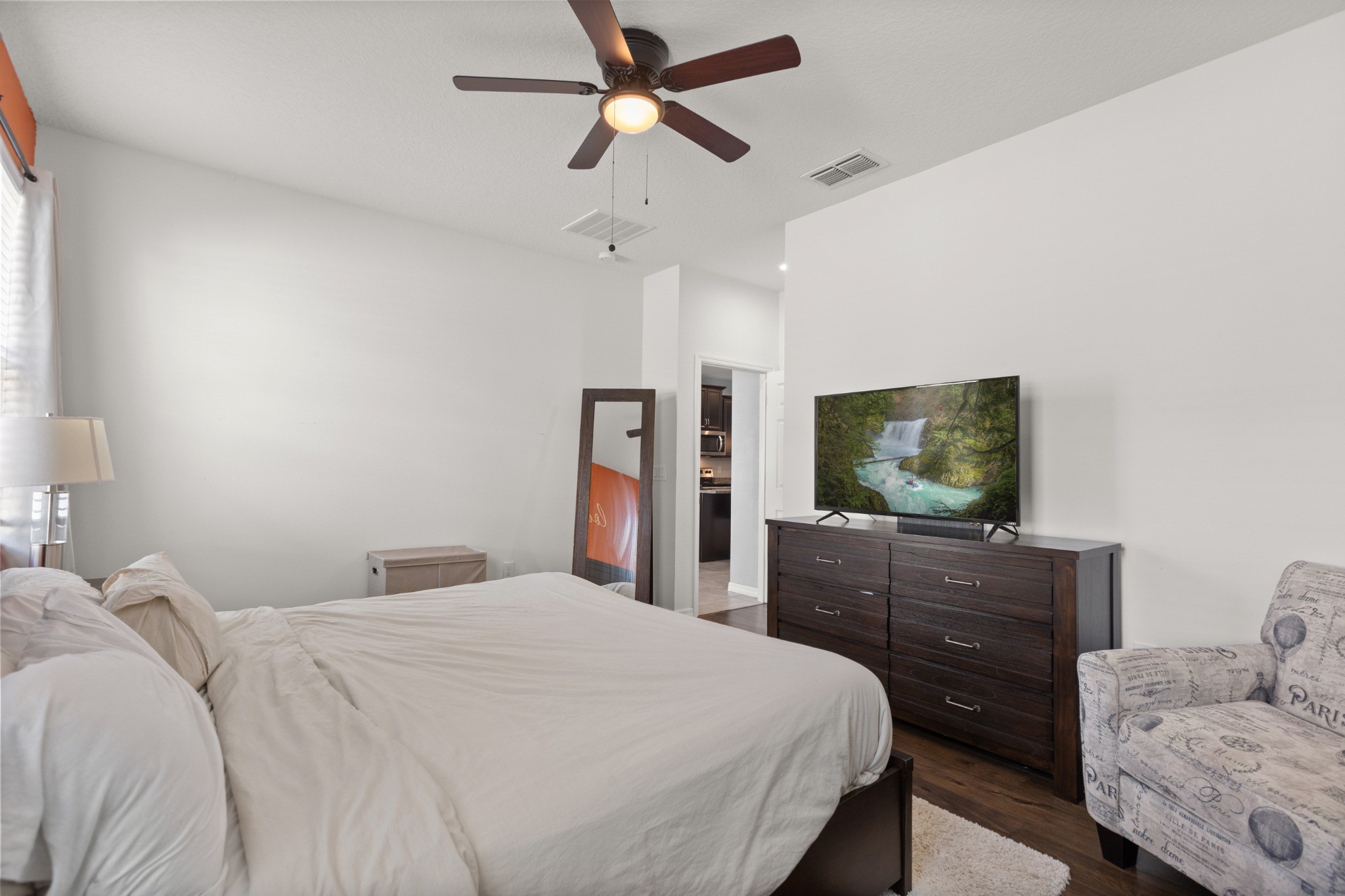 2401 Avian Loop Kissimmee FL - Main-floor primary bedroom with high ceiling, ceiling fan, and natural window light