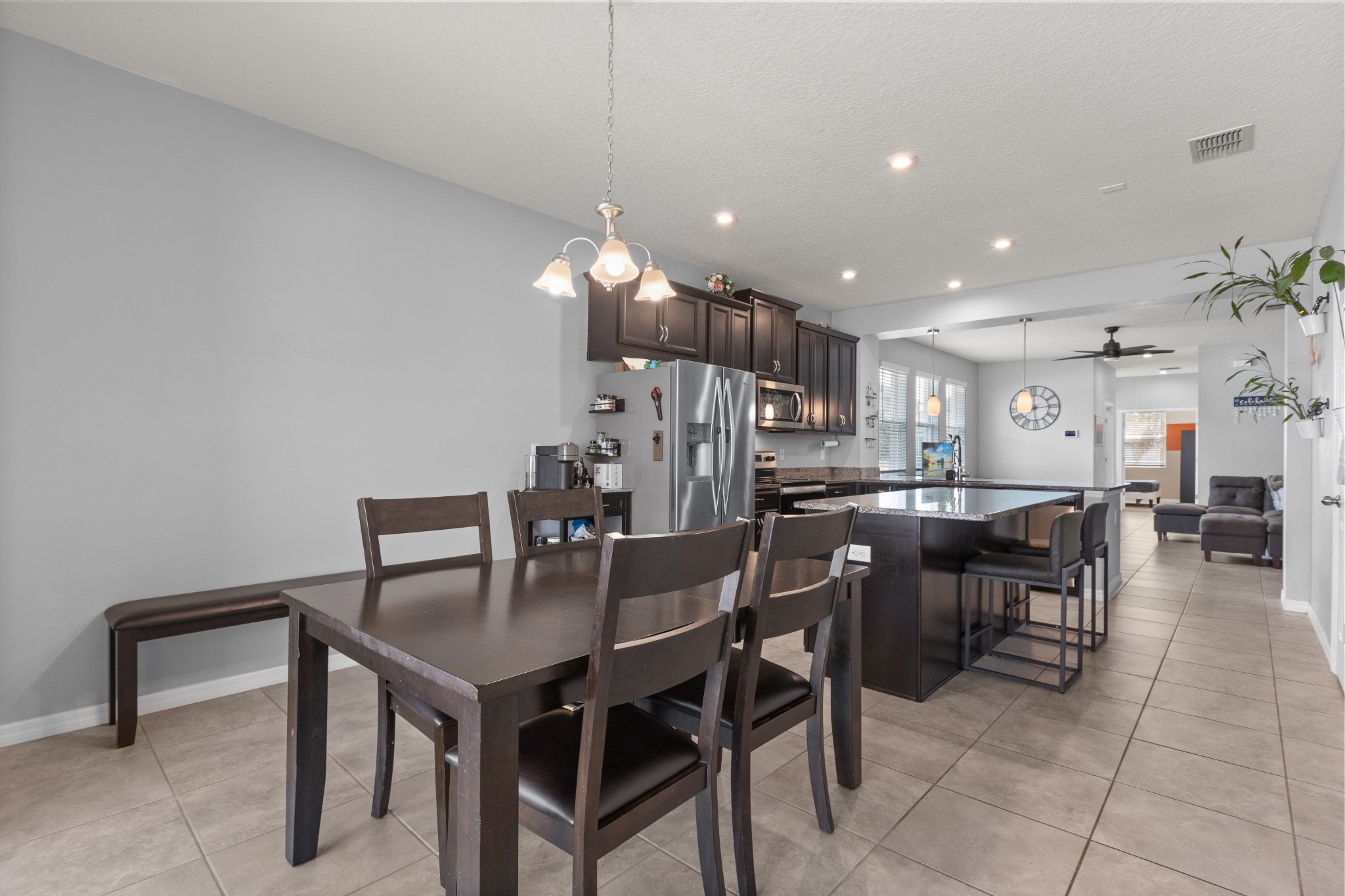2401 Avian Loop Kissimmee FL - Open-concept overview showing dining area, kitchen island, and flowing connection into the main living room