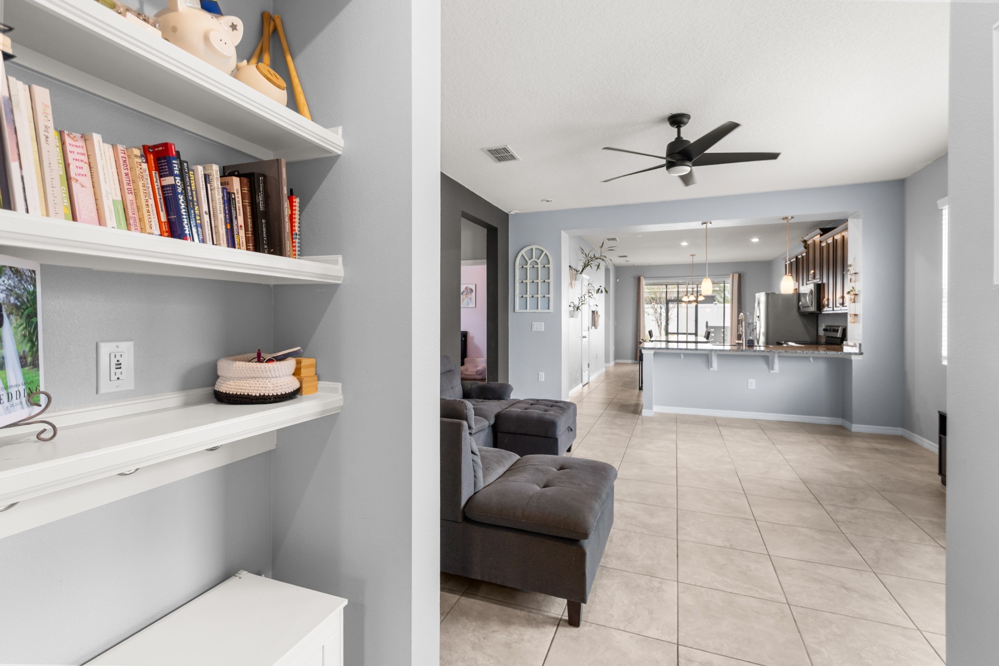 2401 Avian Loop Kissimmee FL - Perspective view across main living area looking through built-in shelving toward kitchen and dining spaces