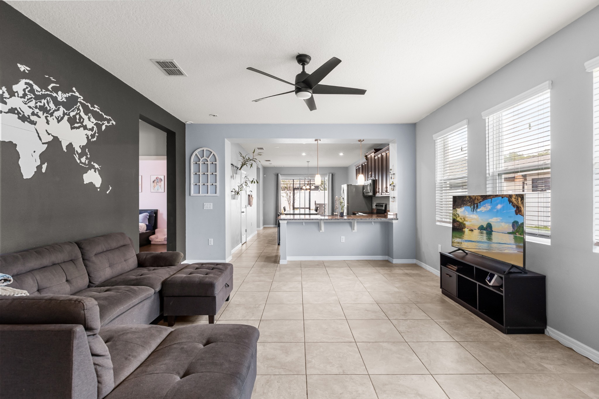 2401 Avian Loop Kissimmee FL - Primary open living room showing high ceilings, abundant natural light, and connection to the kitchen and dining space