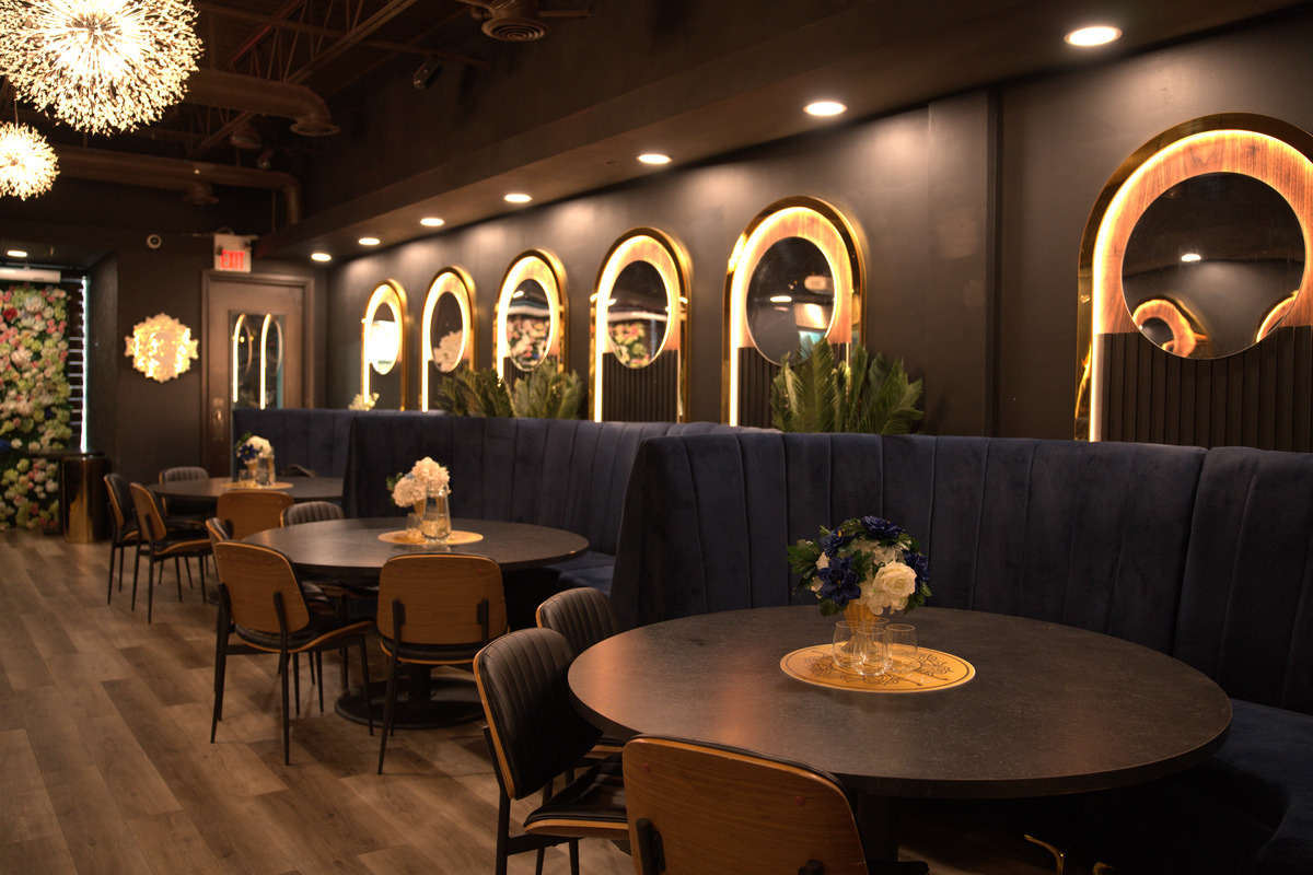 Khatirdari interior party hall Brampton with navy blue velvet booths and gold-trimmed arch mirrors