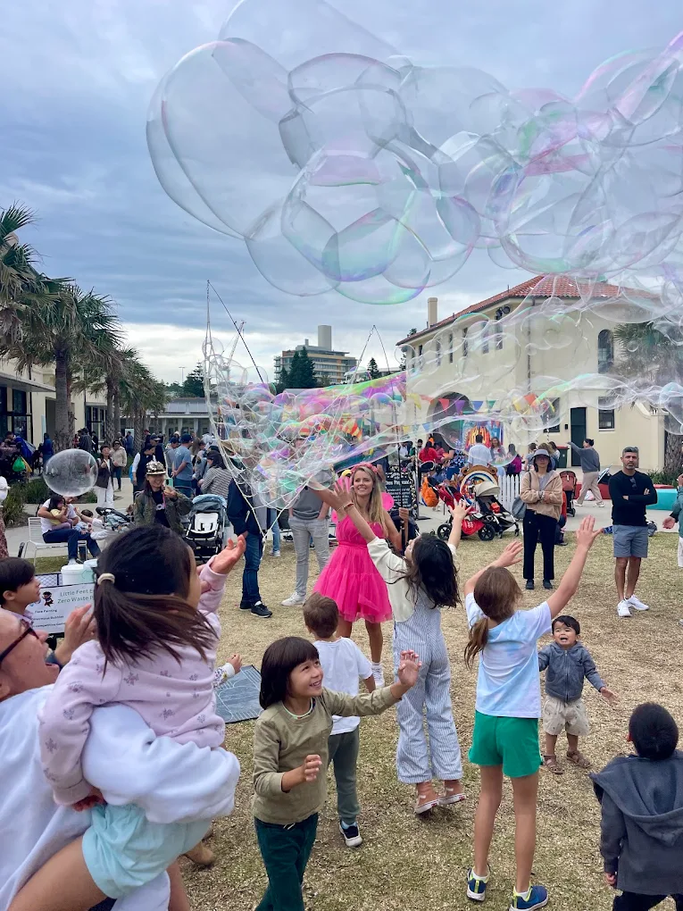 Children enjoying massive bubbles show with party entertainer