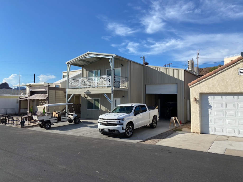 Completed two-story metal shop with a covered balcony and large roll-up bay.