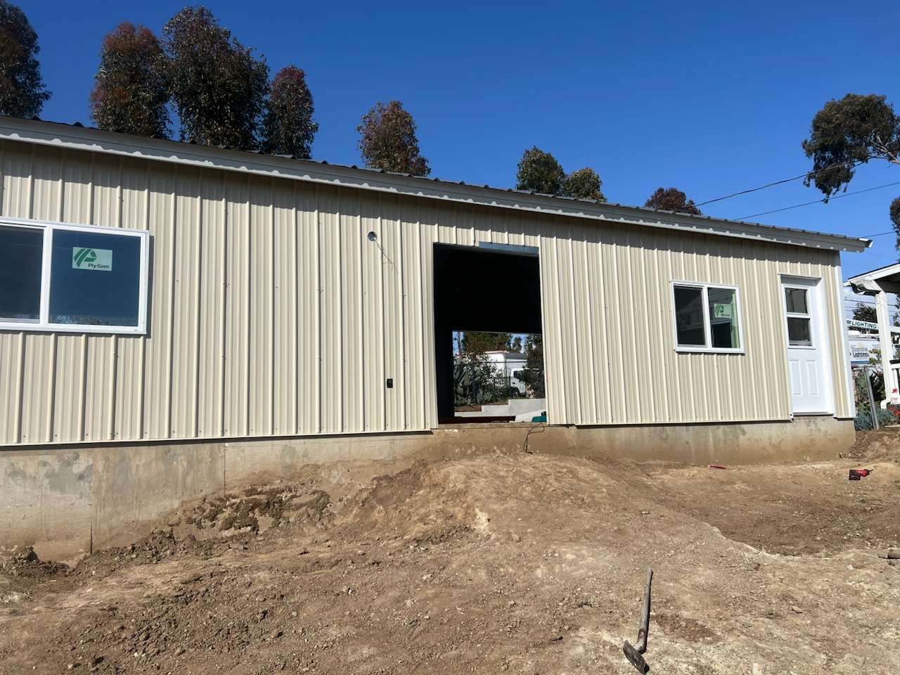 Steel building exterior fitted with metal cladding, windows, and an entry door.