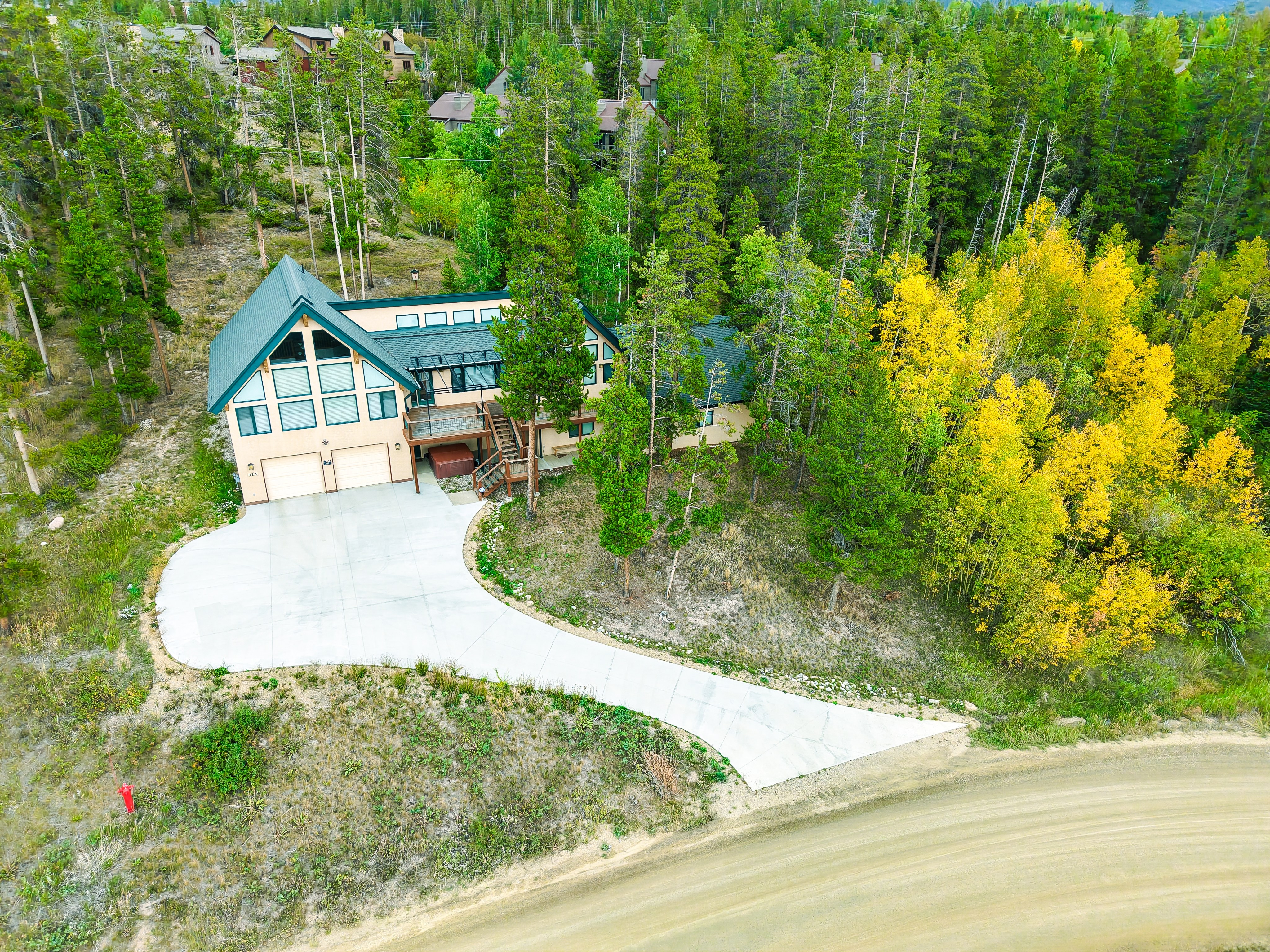 Aerial drone view of mountain property nestled in autumn pines