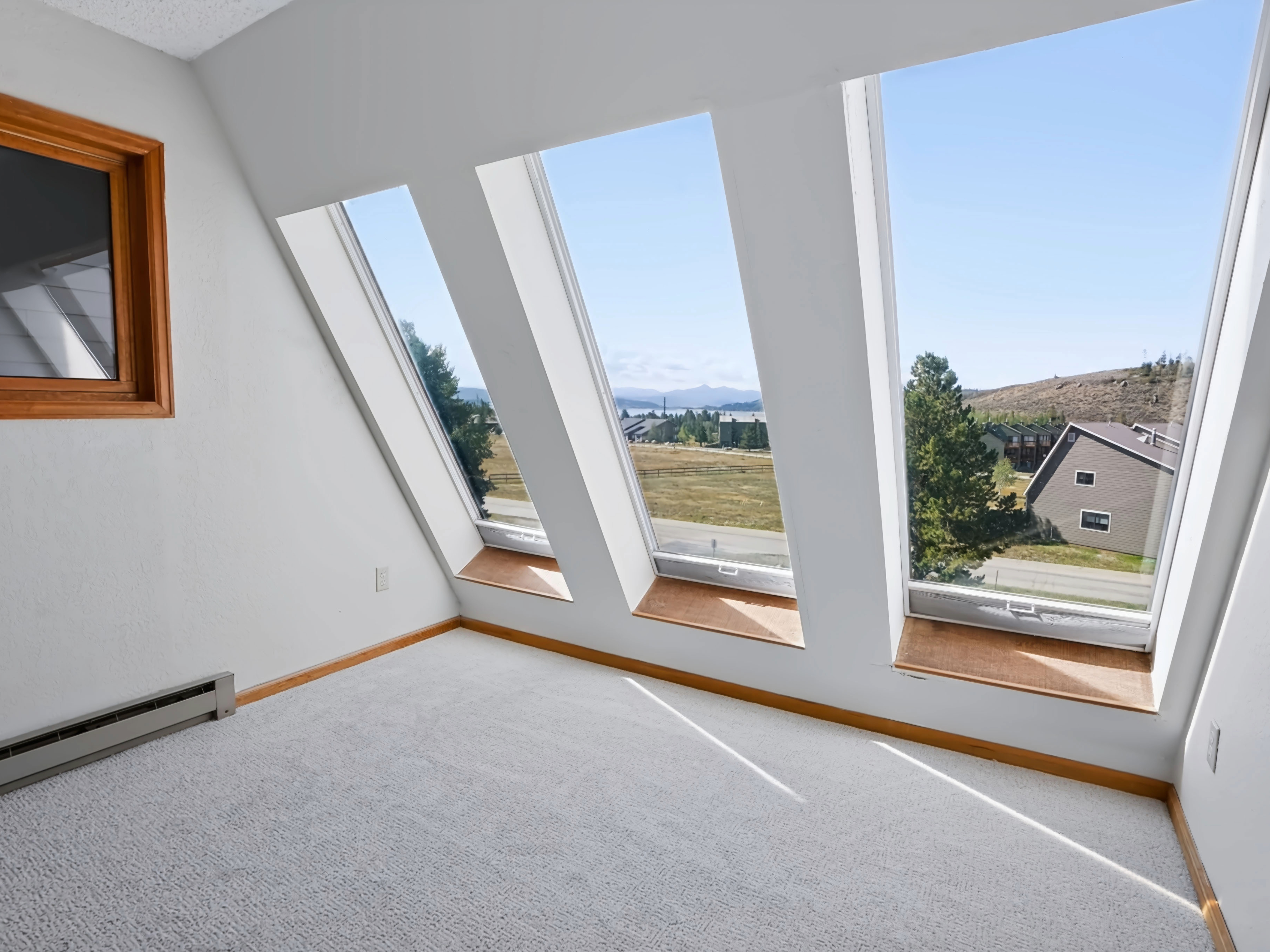 Sunlit mountain loft room with panoramic angled skylights