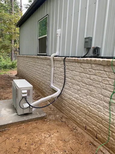 Outdoor mini split condenser with clean line cover on stone wall in Georgetown, TX