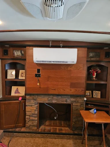 Indoor mini split wall unit above wood fireplace wall in Pflugerville