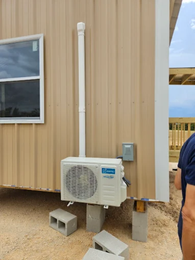 Outdoor mini split heat pump condenser on mounting pad in Round Rock area