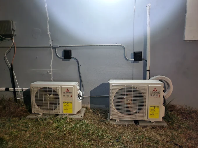 Dual outdoor mini split condenser units installed on concrete pads in Pearland home