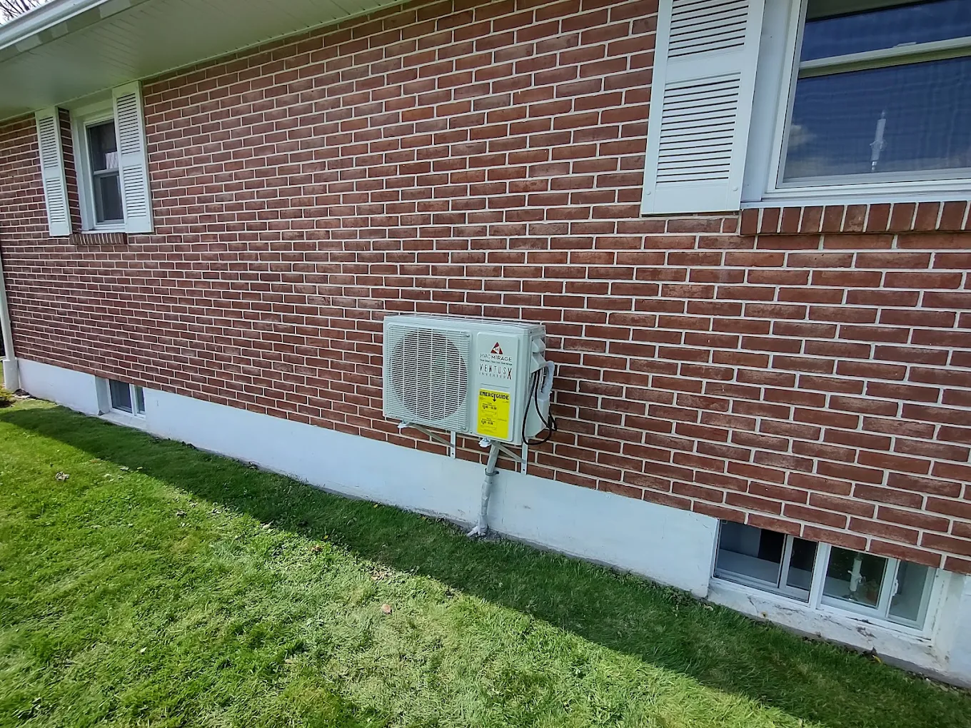 Wall-mounted outdoor mini split unit on brick home exterior in Round Rock, TX